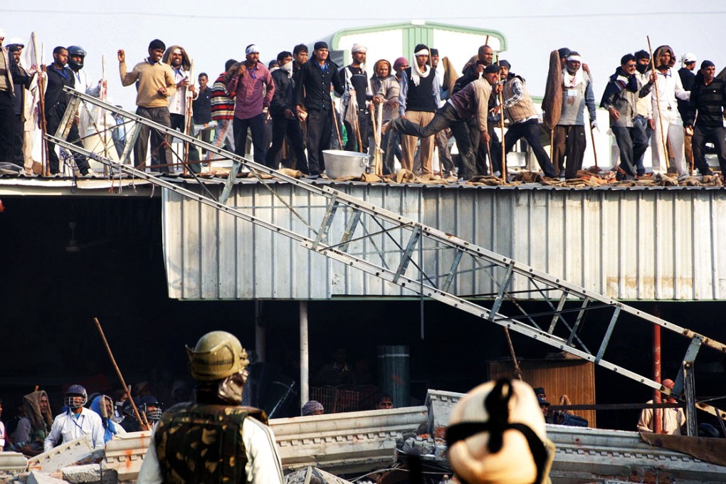 Supporters of controversial guru Rampal Maharaj throw stones at Indian security officials during a confrontation in Hisar. Photo: AFP