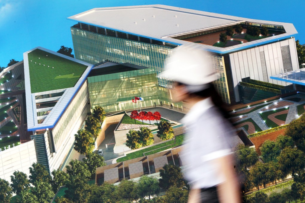 A woman walks past an artist's impression of the new Civil Aviation Department headquarters, at Hong Kong International Airport. Photo: David Wong