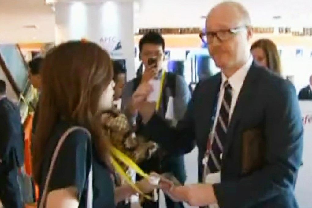 An Apec staff member tries to remove a Now TV reporter's press credentials during last year's Apec summit in Bali. Photo: Now TV