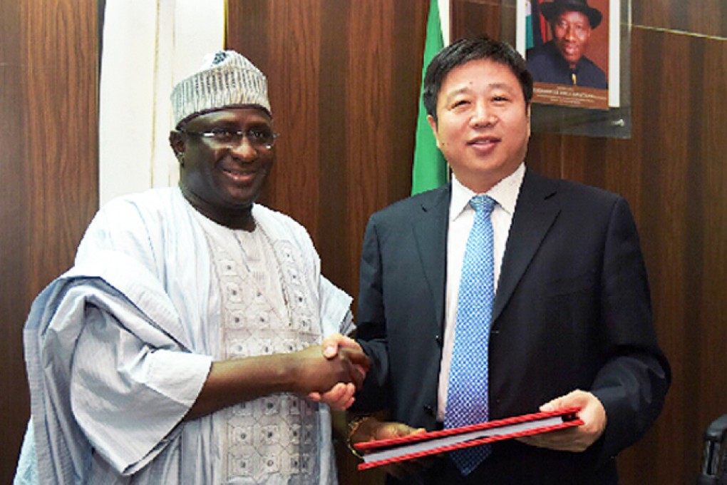 Cao Baogang (right), vice-president of China Railway Construction Corporation (CRCC) China-Africa Construction Limited, shakes hands with Nigeria's Transport Minister, Idris Audu Umar, after signing a contract for a railway project in Nigeria in Abuja on November 19, 2014.