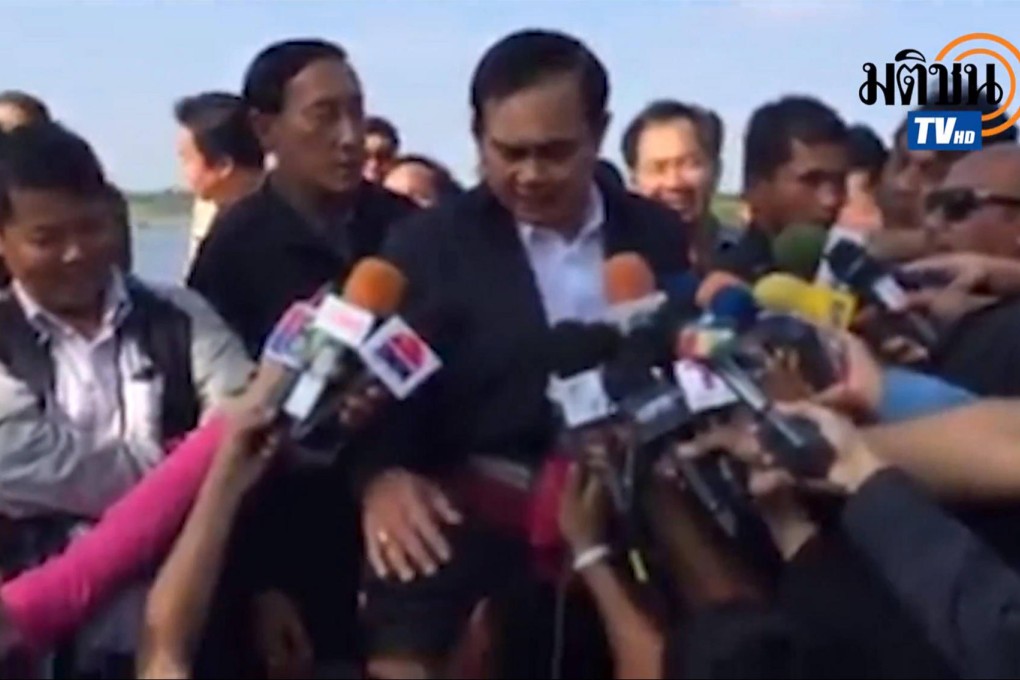 Prime Minister Prayuth Chan-ocha pats the reporter's head.