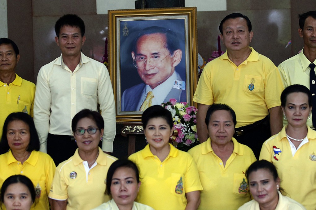 Thai well-wishers wearing yellow shirts in honour of the King Bhumibol Adulyadej, pose for a photo with a picture of the king at Siriraj Hospital in Bangkok on 14 November. Photo: EPA