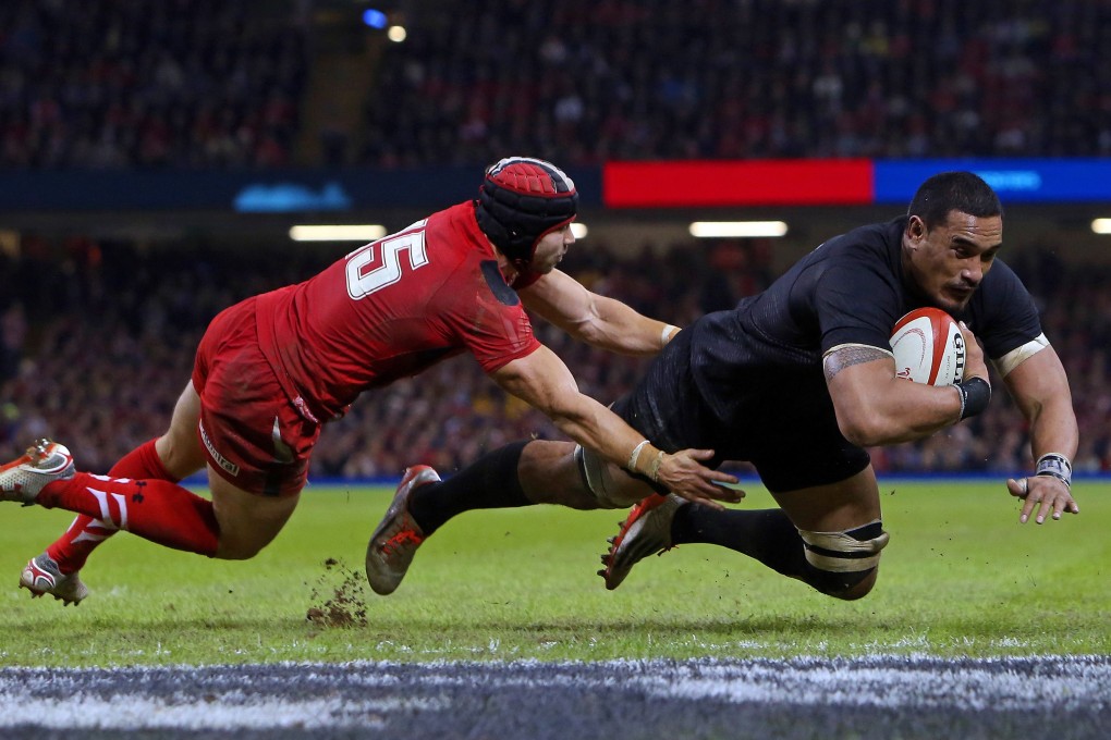Wales fullback Leigh Halfpenny cannot stop flanker Jerome Kaino going over for the All Blacks' second try. Photo: AFP