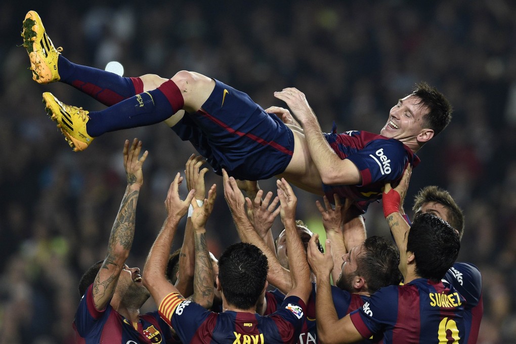 Barcelona's Argentinian forward Lionel Messi is thrown into the air by his teammates as they celebrate his new record after he scored a stunning hat-trick against Sevilla. Photo: AFP