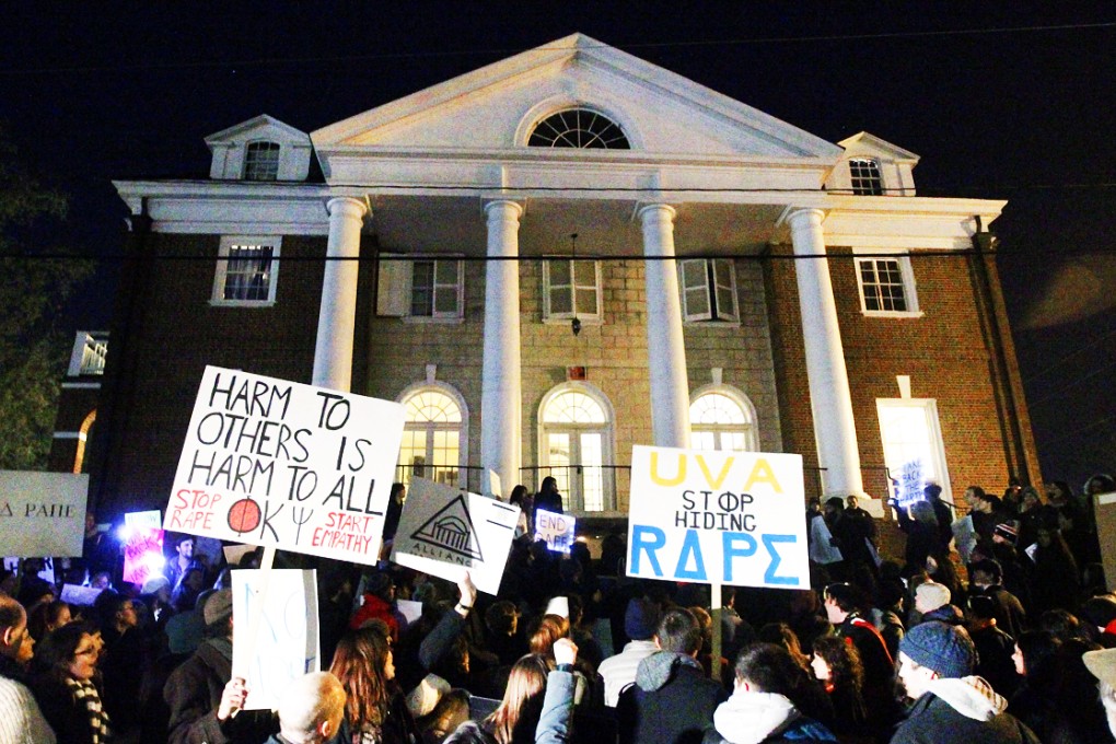 Protestors carry signs and chant slogans in front of the Phi Kappa Psi fraternity house at the University of Virginia. Photo: AP