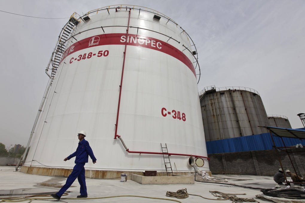 An employee walks past a Sinopec refinery in Hubei province. Profit growth in China's state-owned firms quickened, but there is little signs of a turnaround. Photo: Reuters