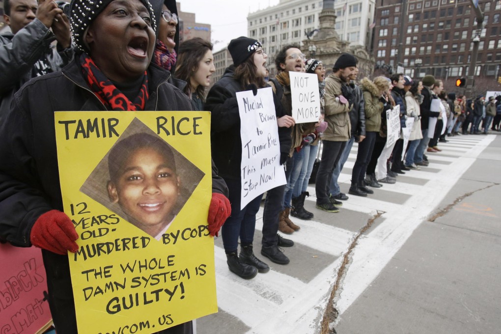 Protesters hold signs featuring Tamir Rice. Photo: AP