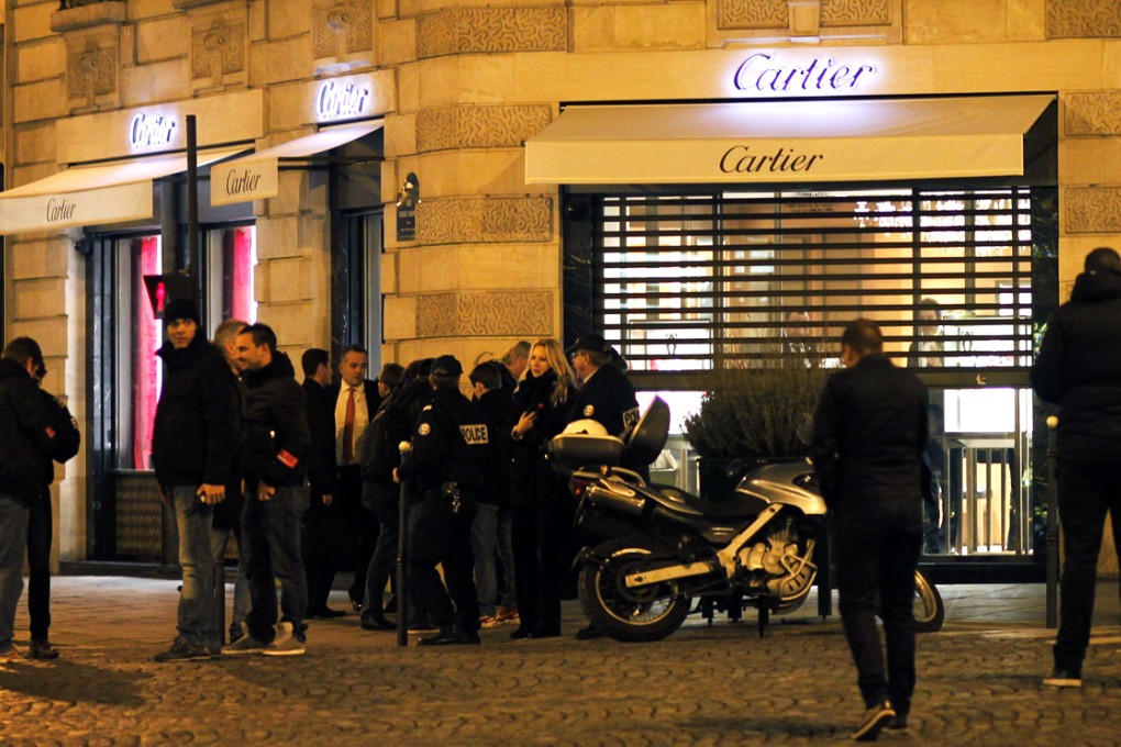 Police officers stand in front of a Cartier jewelery store on the Champs-Elysees avenue in Paris, where a robbery took place. Photo: AFP