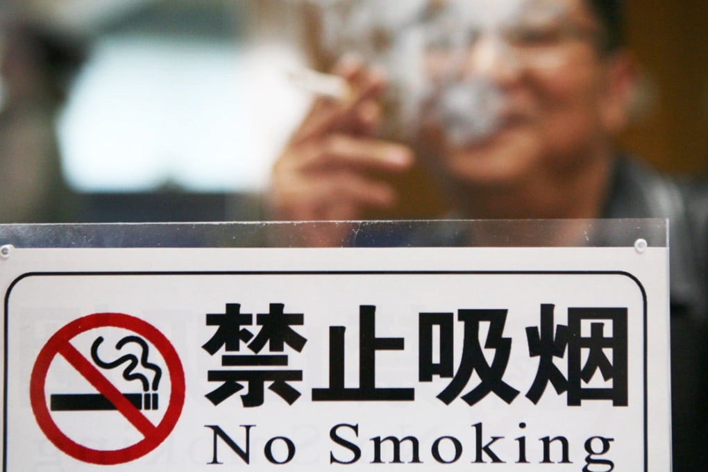 A man lights up in clear sight of a no-smoking sign in Jiangsu province. Photo: Imaginechina