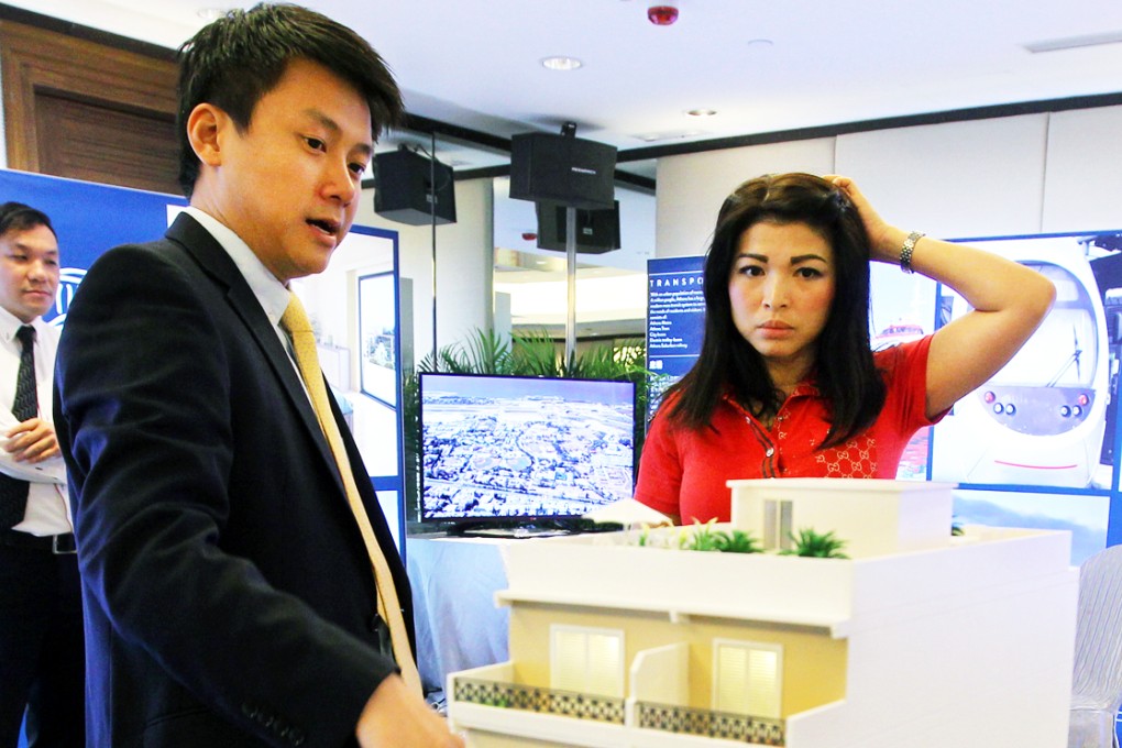 A potential buyer (right) listens to a property sales agent at a showing. Couples need to save for 14 years to buy a 40 square metre flat, a Bauhinia Foundation study found. Photo: Edward Wong