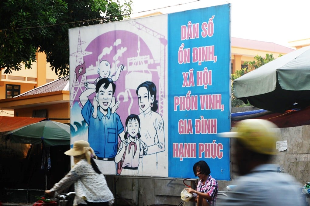 A propaganda poster features the official population policy that encourages families to have two children. Photo: AFP