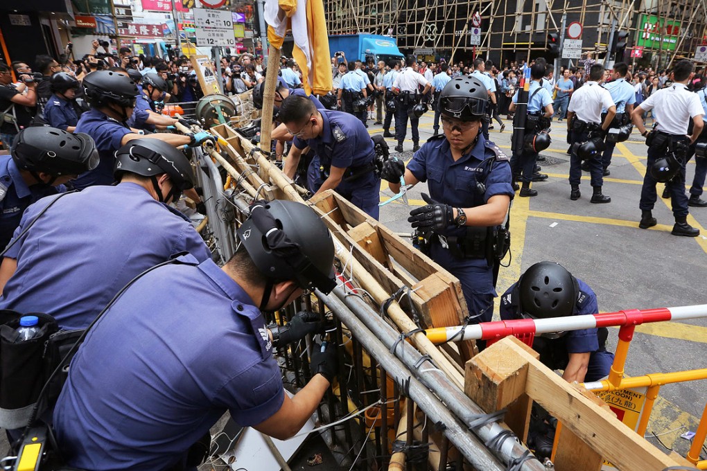 Police remove barricades along Nathan Road in Mong Kok, one of three sites that have been occupied for two months. Photo: Sam Tsang