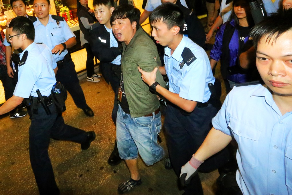 Police officers arrest an Apple Daily cameraman in Mong Kok. Photo: Felix Wong