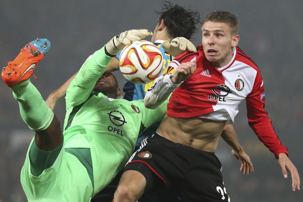 Feyenoord's goalkeeper Kenneth Vermeer loses the ball as he jumps with Sevilla's Alejandro Arribas, rear, and Feyenoord's Sven van Beek, right. Photo: AP