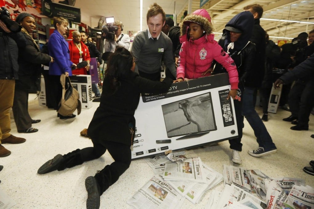 Shoppers at an Asda superstore in Wembley, London, wrestle over a television as they compete for a Black Friday bargain. Photo: Reuters