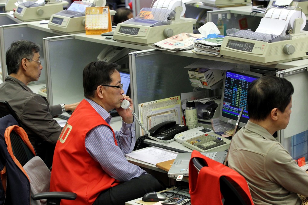 Traders watch their screens in Hong Kong. Hsin Chong Construction, one of the biggest in the city, is planning to raise HK$2.3 billion in a rights and placement. Photo: Edward Wong