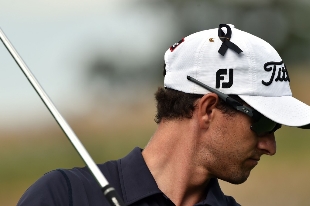 Adam Scott of Australia wears a black ribbon on his cap in memory of Australian cricketer Phillip Hughes on the second day of the Australian Open. Photo: AFP