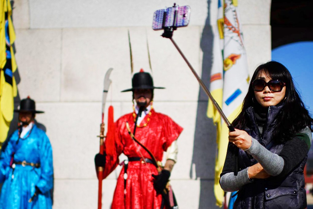 A woman uses a 'selfie stick' at the Gyeongbokgung palace in Seoul, where unregistered devices attract harsh sentences. Photo: AFP