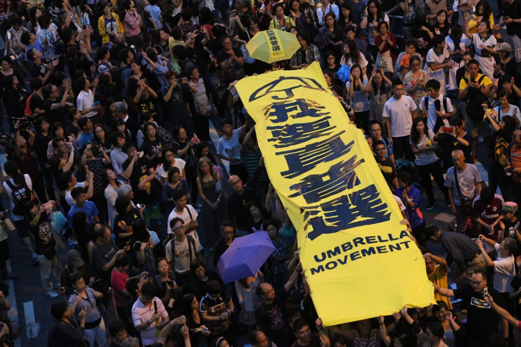 Protesters hold lights and banner saying "I want universal suffrage" in Admiralty. Photo: Felix Wong