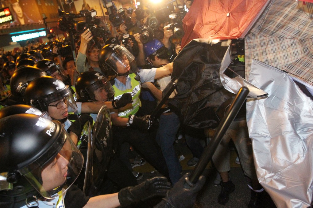 Police clash with protesters holding up umbrellas. Photo: Edward Wong