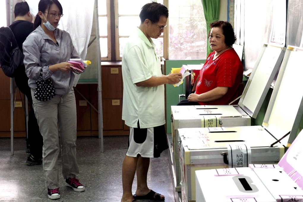 Voters cast their ballots at a polling station in New Taipei City. The KMT held on in the city, a rare highlight for the party. Photo: EPA