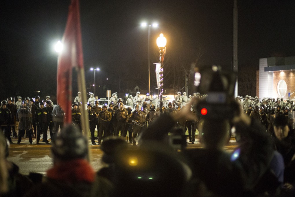 Protesters use a loud speaker to chant and communicate their views toward National Guard and Police Forces in Ferguson. Photo: Xinhua