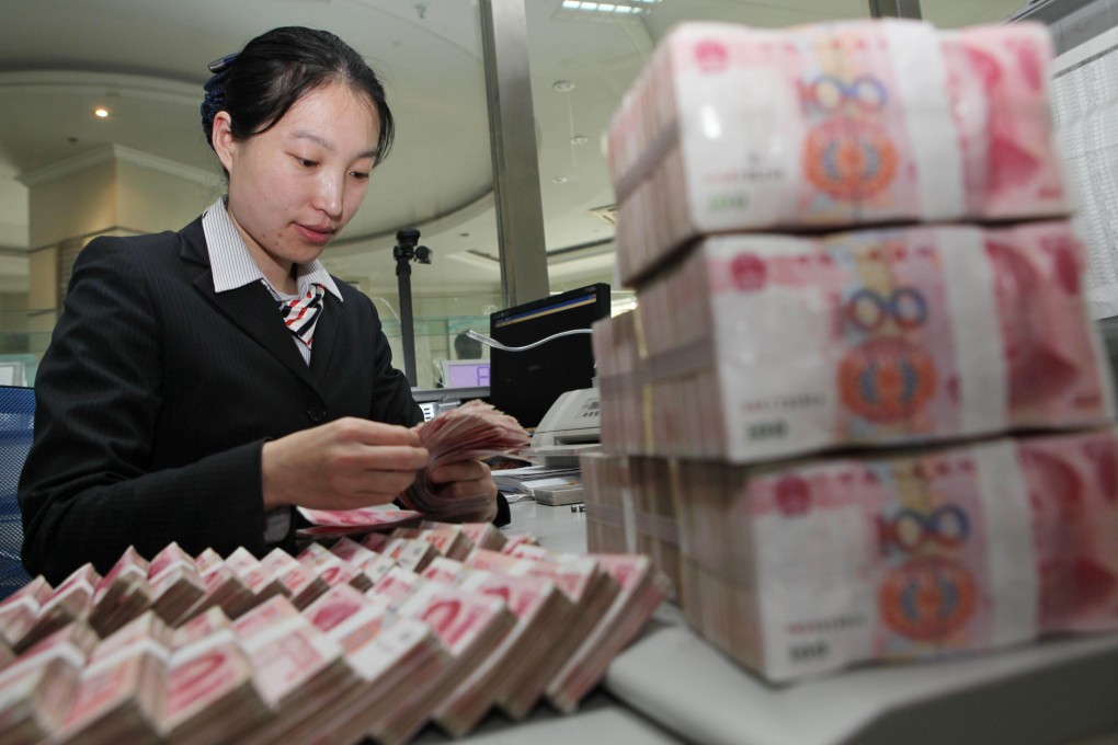 A bank teller counts Chinese yuan notes in Jiangsu province. Ballooning reserves has not been the millstone on the country that some have forecast. Photo: AFP