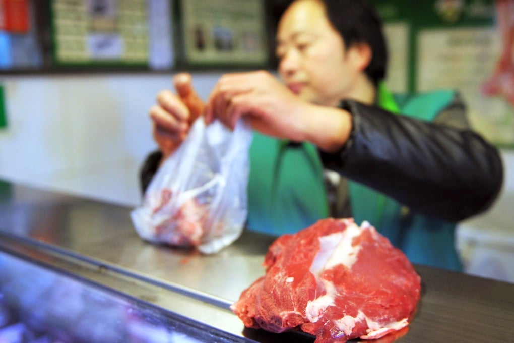 A vendor packages raw beef for sale in a market. Photo: AFP