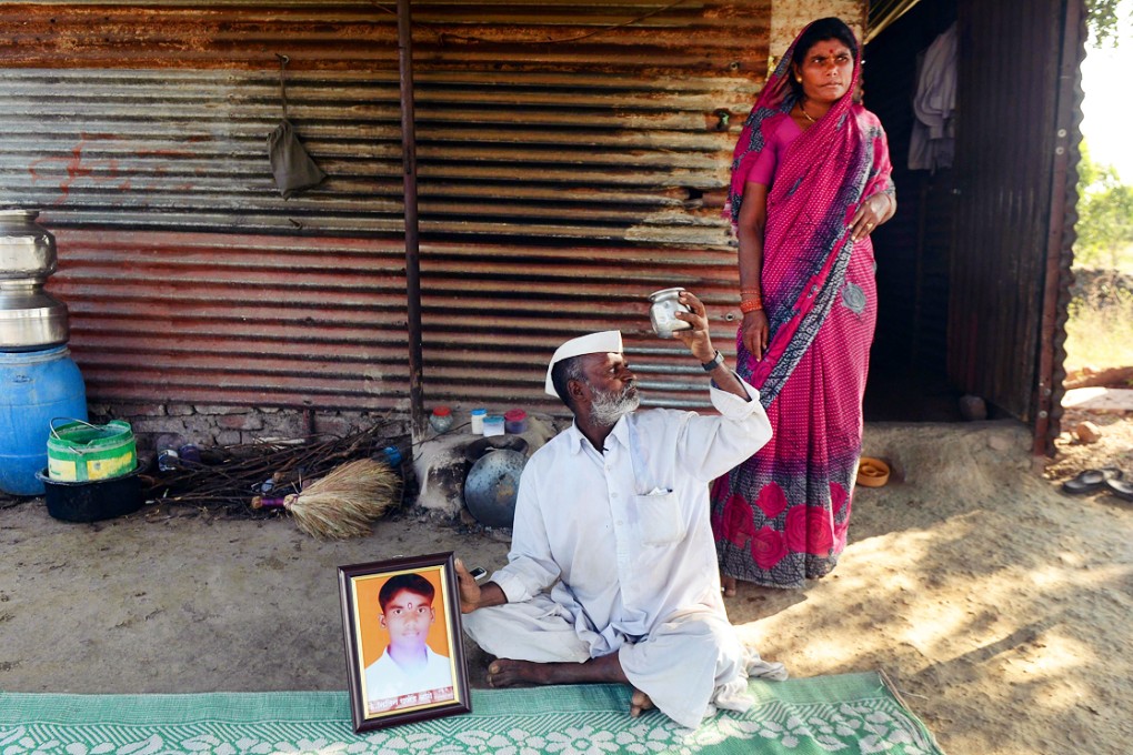 Dalit villager Rajendra Aage and his wife with a picture of their murdered son, Nitin. Photo: AFP