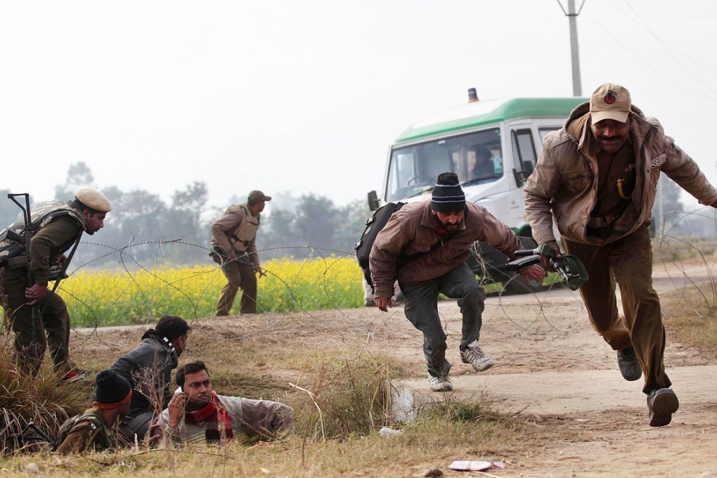 People run for shelter in Indian Kashmir on Friday. Photo: AFP