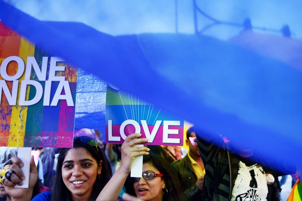 Indian members and supporters of the lesbian, gay, bisexual, transgender (LGBT) community hold placards as they walk underneath a rainbow flag during the Gay Pride Parade. Photo: AFP