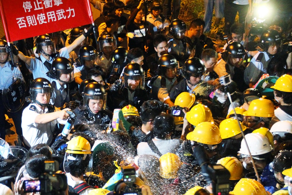 Police use pepper spray on pro-democracy protesters outside government headquarters in Tamar. Photo: Edward Wong