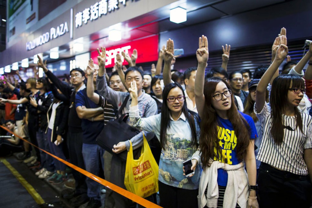 Pro-democracy protesters imitate a three-finger salute from the movie "The Hunger Games", at Mong Kok shopping district. Photo: Reuters