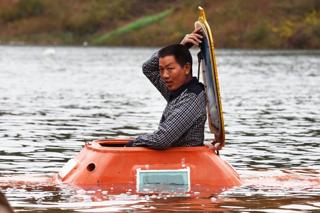 Farmer-turned-inventor Tan Yong in his homemade orange submarine. Photo: AFP