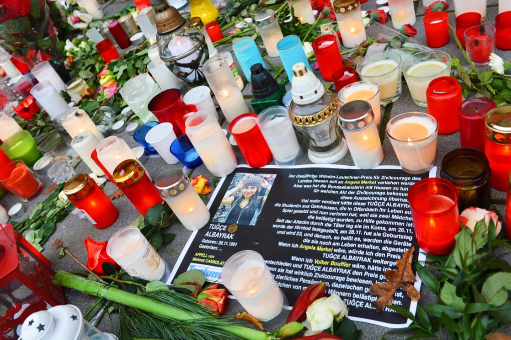 Candles and flowers are placed in commemoration of Tuçe Albayrak in front of the hospital in Offenbach, Germany, where her parents ended life support. Photo: EPA