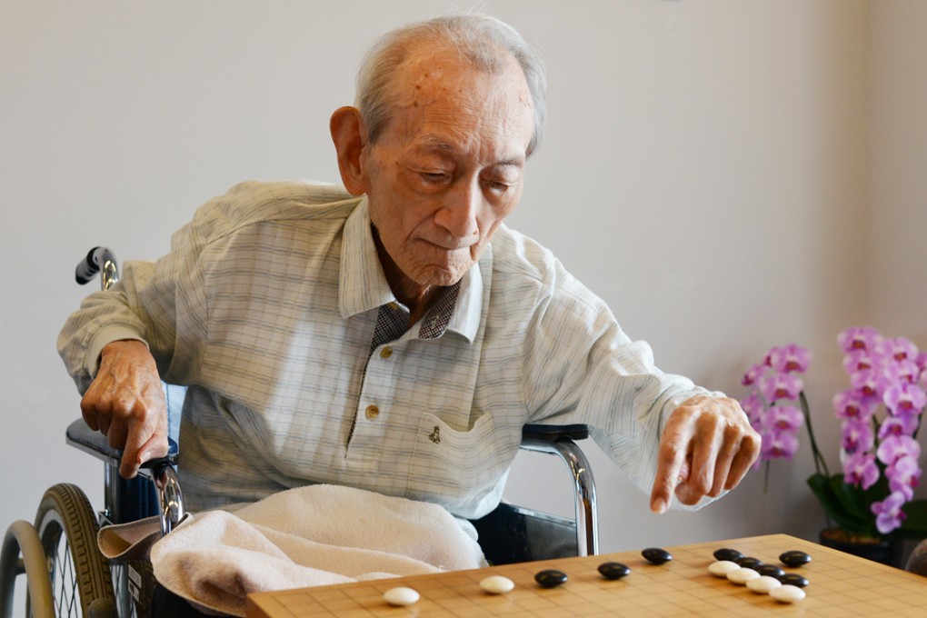 Wu Qingyuan plays Go at a nursing home in Japan in June 2014. Photo: China Foto Press