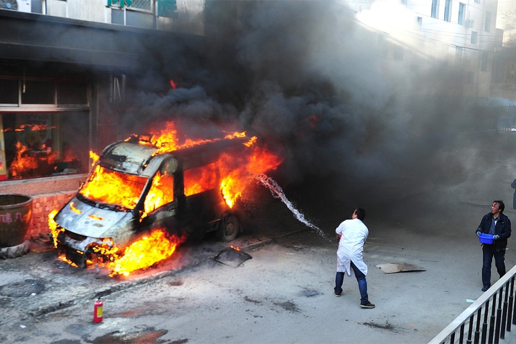 Rescuers battle an ambulance fire outside a pharmacy in Yinchuan, Ningxia. The emergency vehicle erupted into flames when the driver tried to heat the fuel tank because of the cold weather. Photo: China Foto Press