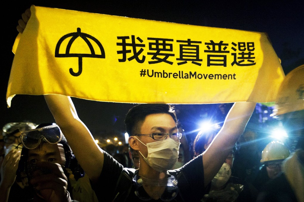 A pro-democracy protester holds up a banner on Lung Wo Road. Photo: EPA