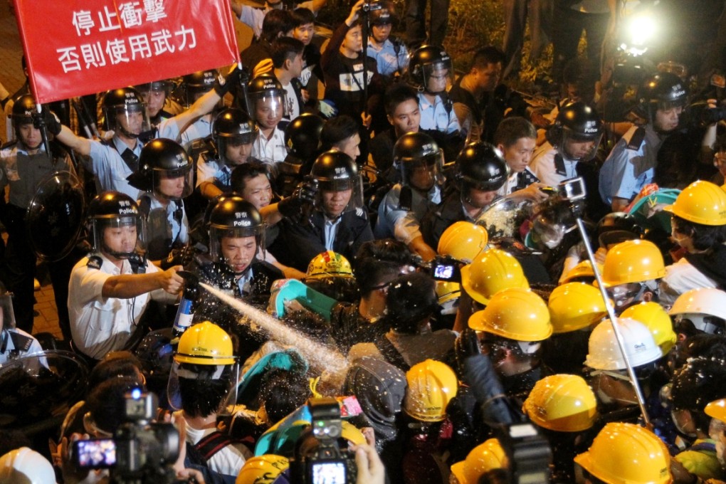Police officers clash with pro-democracy protesters outside Central Government Offices on November 30. Photo: Edward Wong