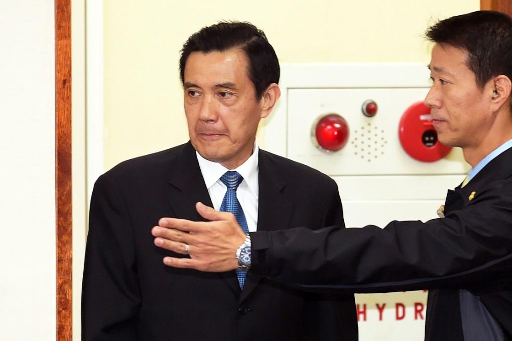 Taiwan's President Ma Ying-jeou is guided by a security official on the day he stepped down as the Kuomintang party's chairman. Photo AFP