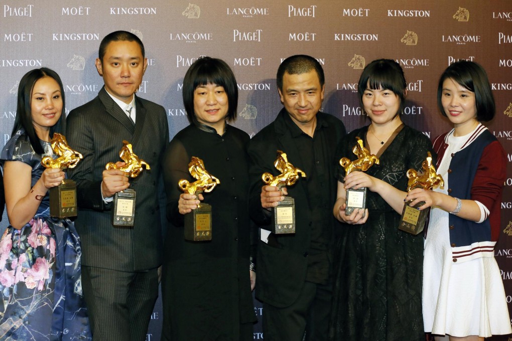 Lou Ye (third from right) and his production team hold the trophies picked up byBlind Massage at Taiwan's Golden Horse awards. Photo: AP