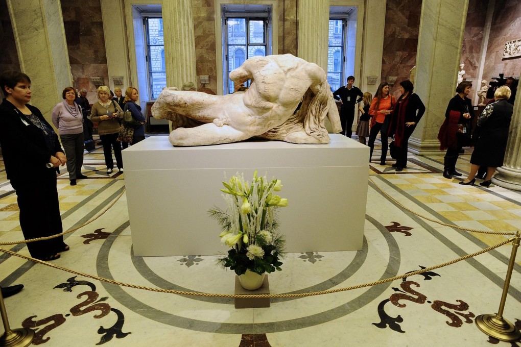 Visitors look at the sculpture of the Greek river god Ilissos at the State Hermitage Museum in St. Petersburg, Russia. The statue will be displayed until January 18. Photo: AFP