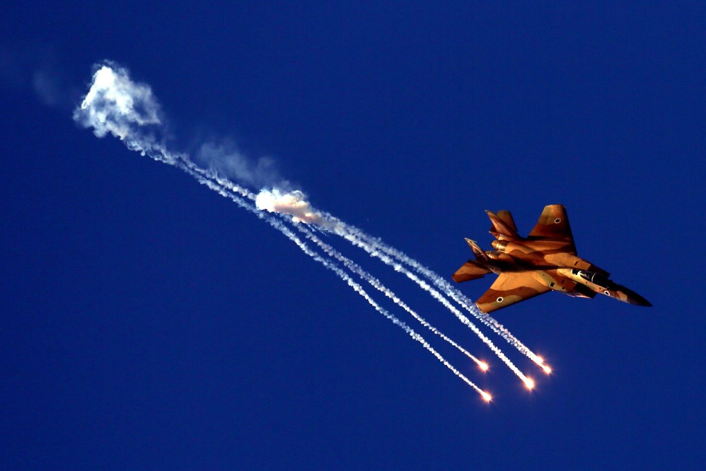 An Israeli Air Force F-15I Ra'am jet demonstrating its flight maneuvering abilities while distraction flares illuminate the sky during an air show. Photo: EPA