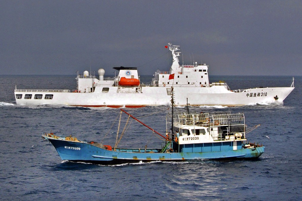 A Chinese fishery administration ship, background, guards a Chinese fishing vessel near the disputed Spratly islands in the South China Sea. Photo: Xinhua