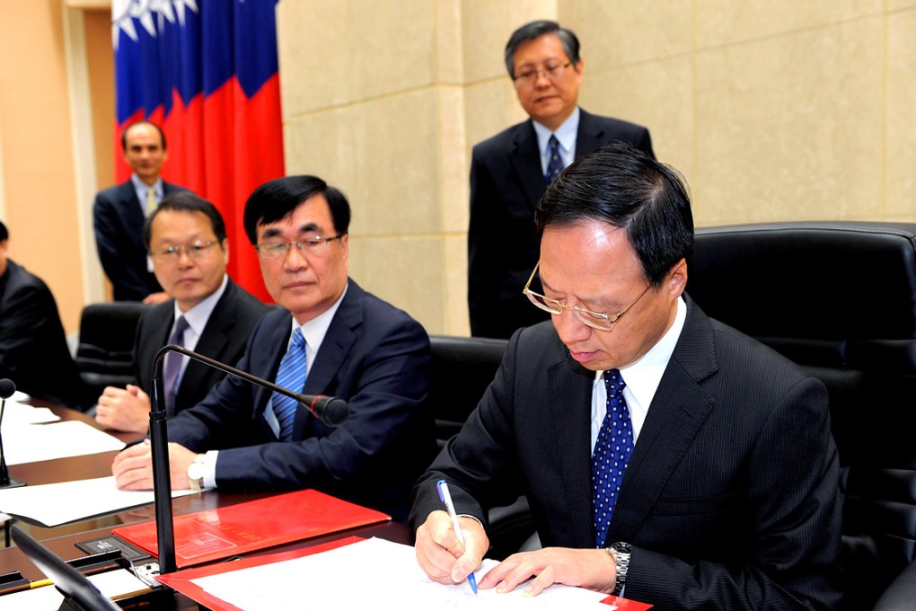 Former Taiwanese premier Jiang Yi-huah (far right) signs the order on his cabinet's resignation after the ruling Kuomintang's crushing defeat last week. Mao Chi-kuo takes his place as the new premier. Photo: EPA