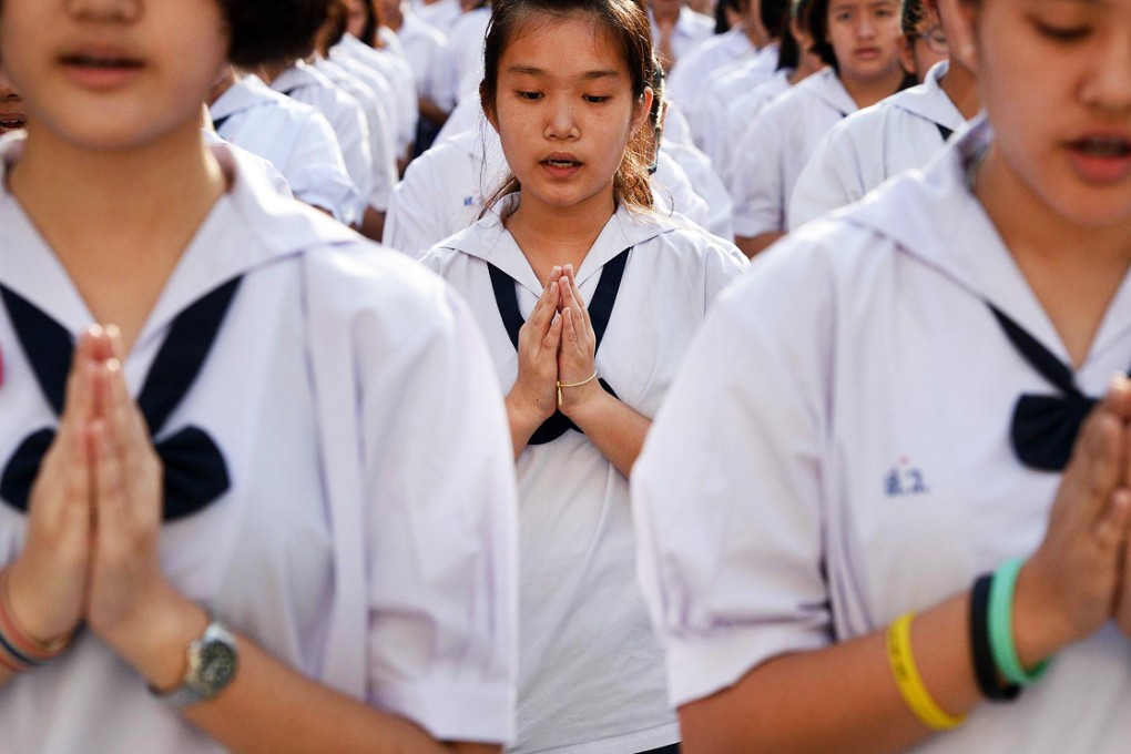 Thai students offer Buddhist prayers at a school in Bangkok. The country's rulers are encouraging deference to authority. Photo: AFP
