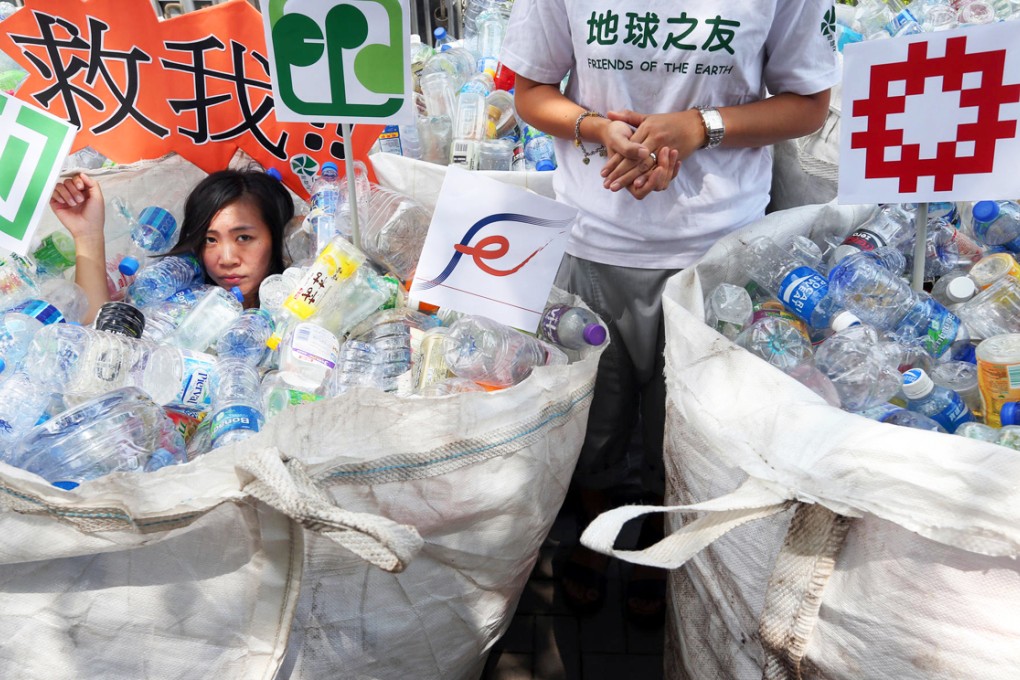 Celia Fung battles with more than 1,000 plastic bottles left by protesters outside government headquarters in Tamar. Photo: Sam Tsang