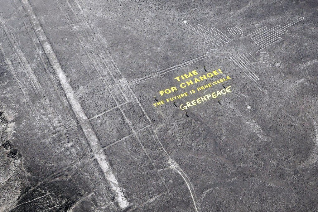 A banner unfurled by activists beside the historic Nazca Lines in a desert in Peru. Photo: Reuters