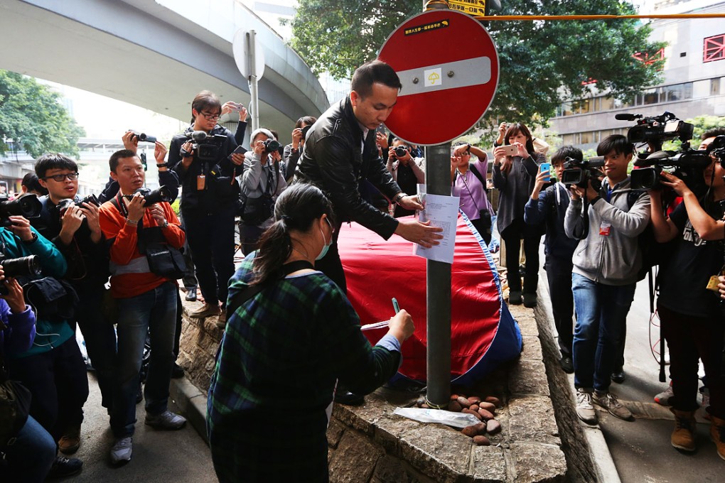 Lawyers post a court injunction notice in Admiralty on Tuesday afternoon. Photo: Sam Tsang