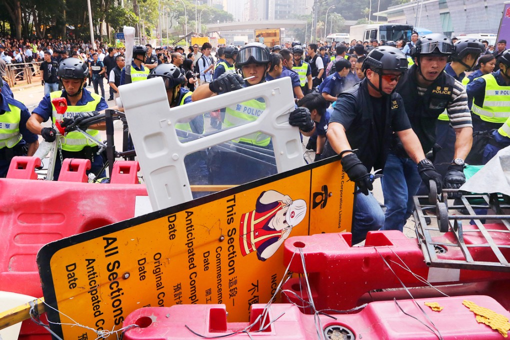 Police officers remove the barricades on Queensway in Admiralty. Photo: Sam Tsang